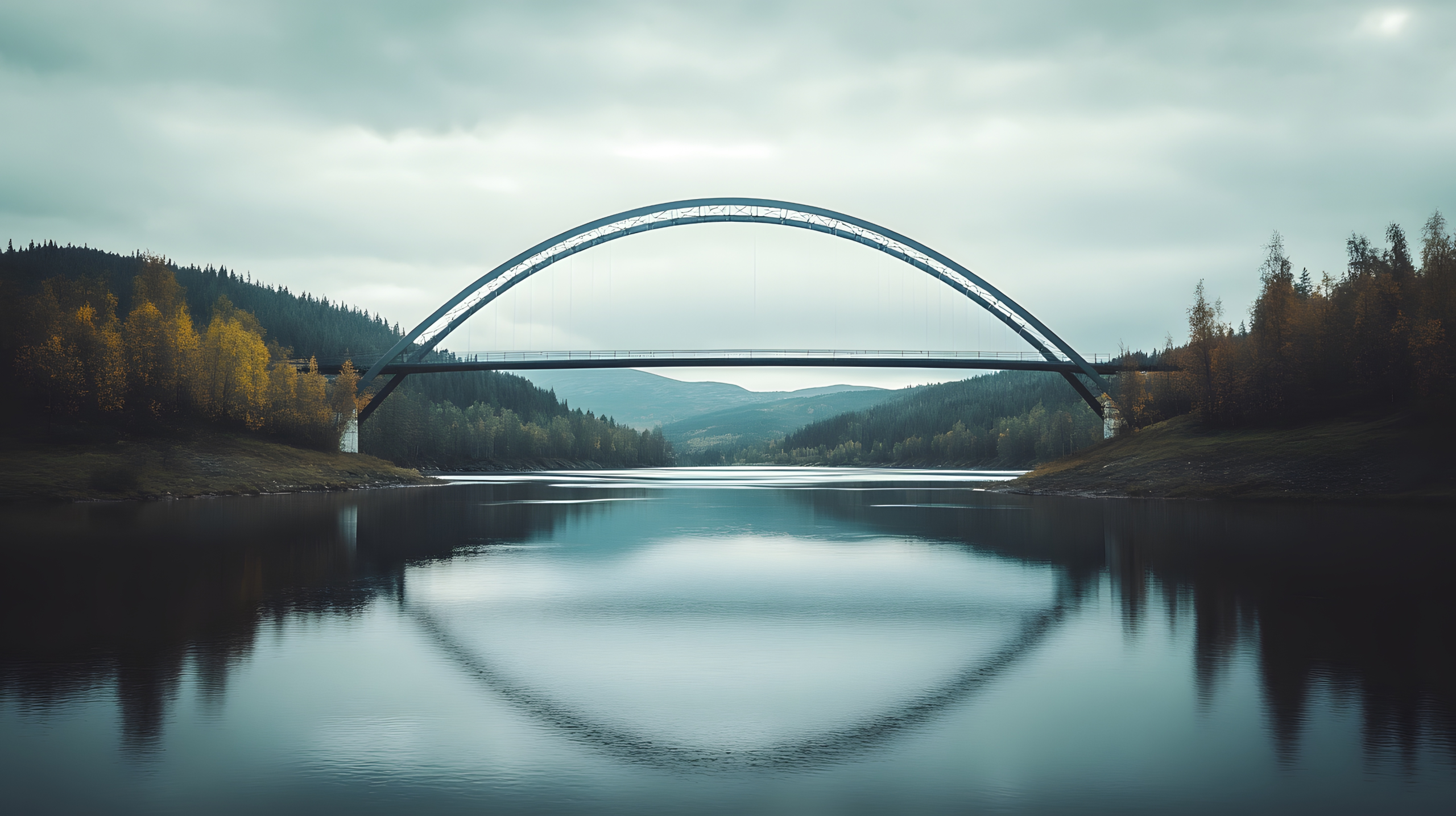Scenic bridge over calm water with forest and mountain views